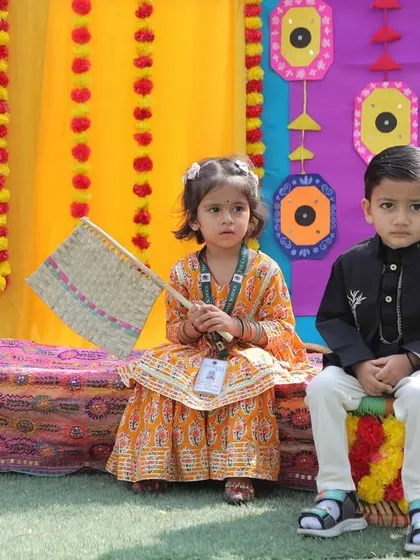 Two children in traditional outfits posing against the colorful Baisakhi decor. These events are a wonderful opportunity for kids to learn about different cultures.