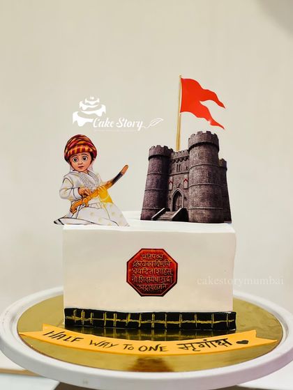 A square cake for a 'Halfway to One' celebration with a Shiv Jayanti theme. It's a wonderful way to introduce little ones to our heritage.