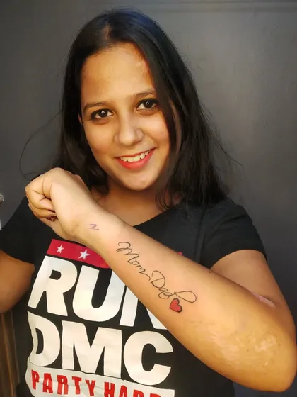A classic "Mom Dad" tattoo with a small heart. This is one of the most popular requests I get, and I always make sure the script is clean and elegant.