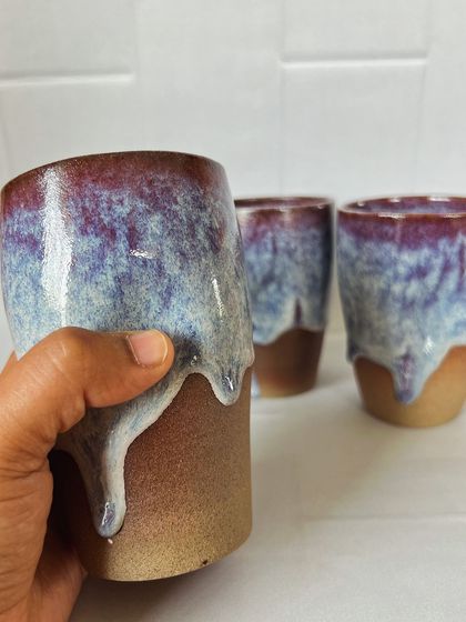 A closer look at one of the grip tumblers. The glaze drips down the side, creating a unique pattern on each piece. The top half is glossy while the bottom half is raw, textured clay.
