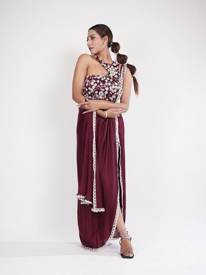 This wine-colored Indo-Western outfit with a thigh-high slit is both bold and elegant. The one-shoulder embroidered top adds a unique touch.