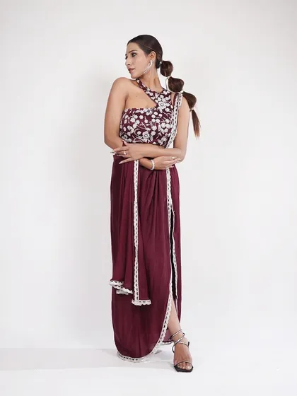 This wine-colored Indo-Western outfit with a thigh-high slit is both bold and elegant. The one-shoulder embroidered top adds a unique touch.