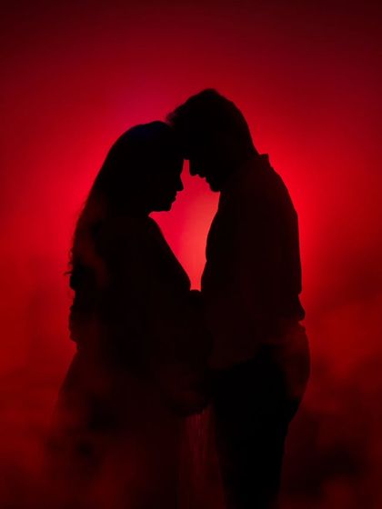 A dramatic and passionate silhouette of a couple, enveloped in red mist for a truly artistic and memorable shot.