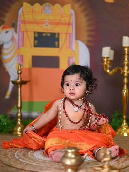 A unique and respectful photoshoot theme of a baby dressed as the revered saint, Raghavendra Swamy.