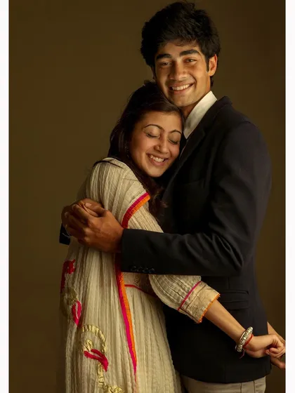 A joyful studio portrait of a brother and sister, capturing their happy and affectionate relationship. The warm lighting and genuine smiles make this a cherished family photograph.
