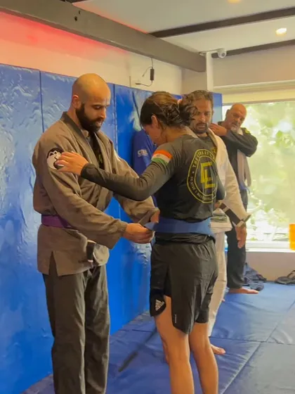 A belt promotion ceremony. Here, a student is awarded a new belt, recognizing the time and effort she's put in on the mats.