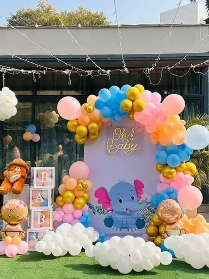 This outdoor baby shower setup was a lot of fun. I used a cute elephant theme with a custom backdrop, a colorful balloon arch, and 'BABY' blocks to welcome the little one.