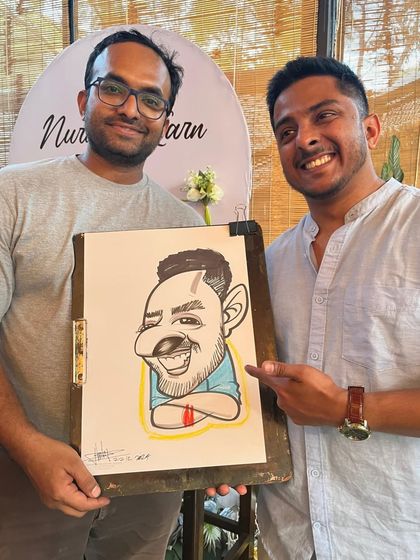 Pointing out the resemblance. It's always fun to see guests compare the caricature to the real person.