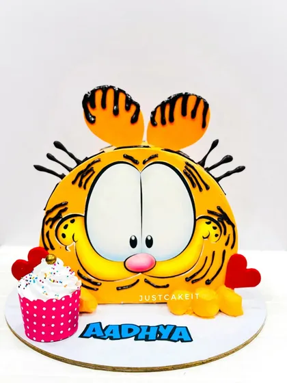 A fun, shaped cake of Garfield's face. This design uses buttercream and minimal fondant to create the iconic cartoon cat, complete with a small cupcake.