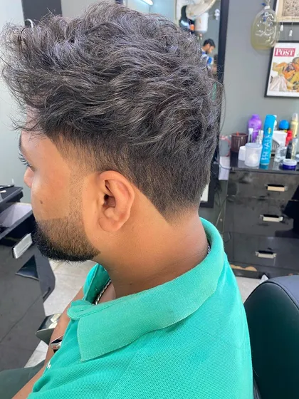 This style combines a messy, textured top with a sharp, faded V-shape at the nape. It’s a great example of how I can balance a relaxed style with the clean lines of a precision haircut.