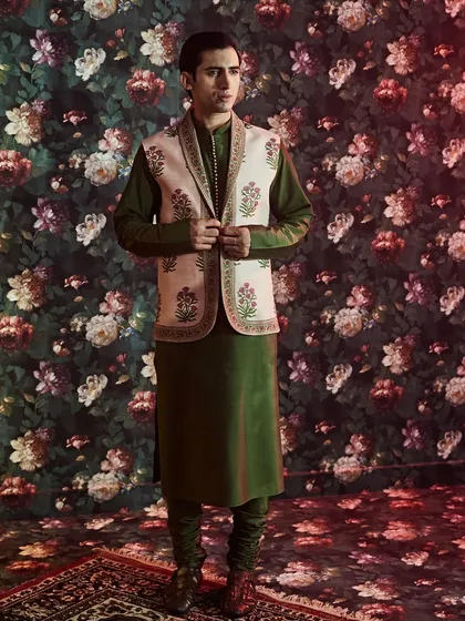 This ensemble pairs a forest green raw silk kurta with a classic Nehru jacket featuring authentic Jaipuri hand block prints, showcasing our dedication to heritage crafts.