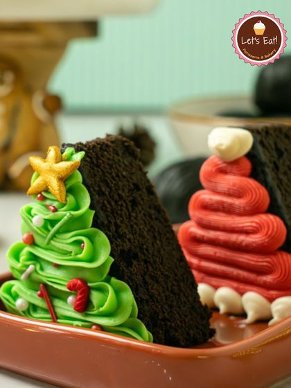 Slices of rich chocolate cake decorated with festive buttercream Christmas trees. These individual portions are perfect for holiday parties and gatherings.