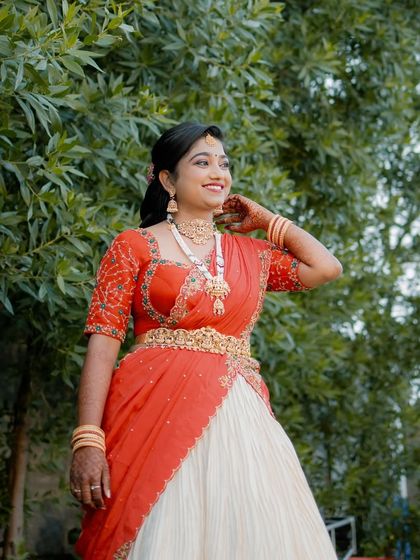 Radiant and glowing! My cherished client Harshitha dazzles on her engagement day in this custom-made red and ivory half saree that I crafted for her in under a week. She looks absolutely stunning.