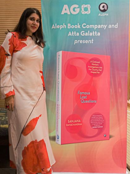 An author posing with a promotional standee for her book 'Famous Last Questions' at our bookstore.