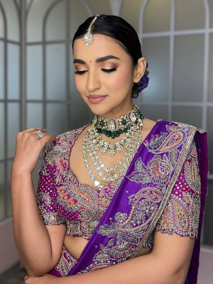 A soft, elegant pose that highlights the beautiful embroidery on the blouse and the delicate shimmer of the eyeshadow. The look is both bold in color and soft in its application.