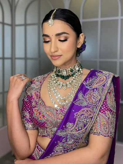 A soft, elegant pose that highlights the beautiful embroidery on the blouse and the delicate shimmer of the eyeshadow. The look is both bold in color and soft in its application.