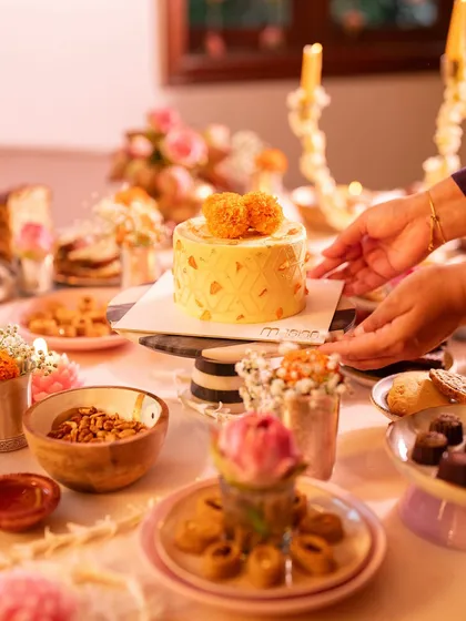 Placing our signature Marigold Cake on the dessert table. It's a proud moment to see it become the centerpiece of a celebration.
