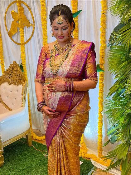 A full-length view of Usha's baby shower attire. I ensure the saree draping is perfect and comfortable, allowing the mom-to-be to move with ease.