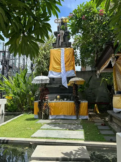 A traditional Balinese shrine, adorned with offerings and surrounded by lush greenery. The harmonious blend of spirituality, nature, and architecture is a key element of Balinese design.