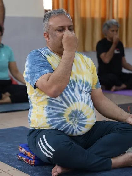 A student uses a meditation cushion to maintain a comfortable and erect posture during pranayama practice. Proper posture is key to receiving the full benefits.