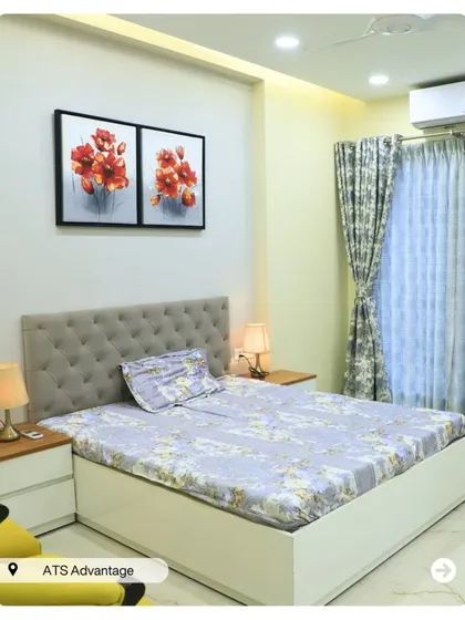 A calm and soothing bedroom with a simple tufted headboard and floral artwork. The light wood nightstands and lamps create a balanced and peaceful environment.