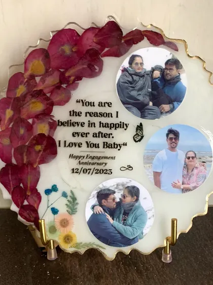 A romantic anniversary frame featuring three photos and a loving quote. The border is decorated with preserved red rose petals.