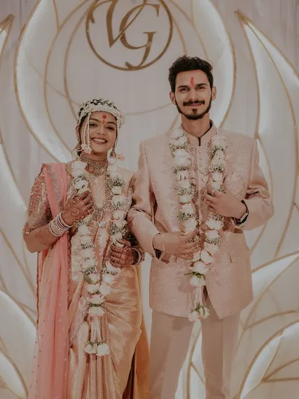 A portrait of the engaged couple, showcasing their matching fresh rose garlands.