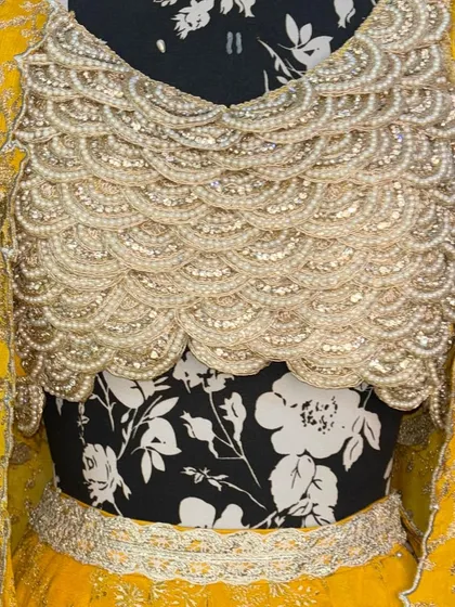 A close-up of the hand-embroidered blouse for our yellow haldi lehenga. The scalloped pearl detailing is one of my favorite elements.