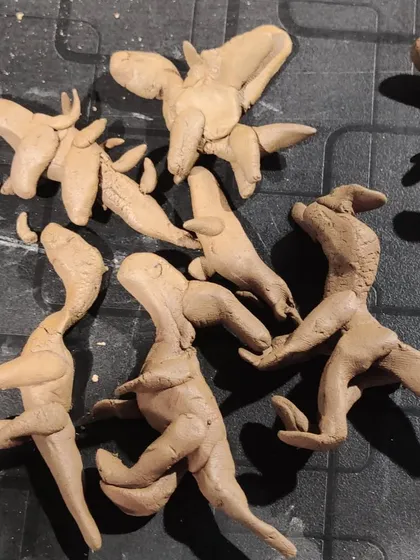 A collection of small, expressive clay dinosaurs. The focus here is not on realism but on the joy of creation and the fun of making a whole family of prehistoric creatures.