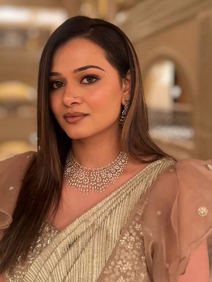 A profile view of the Sangeet look. The makeup is soft and glowing, with a focus on creating a flawless, radiant complexion.