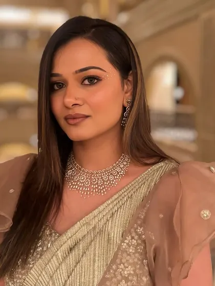 A profile view of the Sangeet look. The makeup is soft and glowing, with a focus on creating a flawless, radiant complexion.