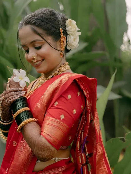 A sweet moment with the bride holding a white flower, her makeup looking soft and romantic.