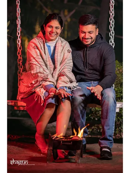 Wrapped in a shawl, sharing smiles by the fire. This candid shot captures the simple joy and warmth of spending a cool evening together, a perfect memory from their Rishikesh trip.