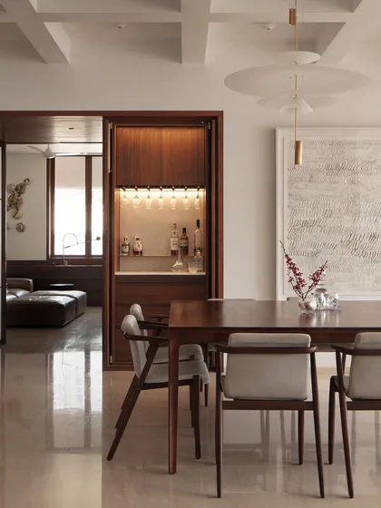 An elegant apartment on Altamount Road, Mumbai, where we focused on soft textures and refined details. The custom-built bar, crafted from rich wood, is seamlessly integrated into the dining space, demonstrating our approach to bespoke, functional furniture.