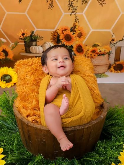 A big, happy smile from this baby in our sunflower bucket setup. The combination of the rustic props and bright flowers makes for a beautiful and joyful portrait.