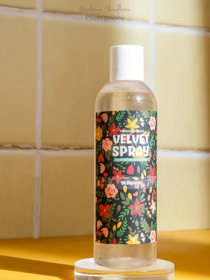 A shot of a body spray using a tiled backdrop and warm, sunny lighting. This setup creates the feeling of a bright, sunlit bathroom.