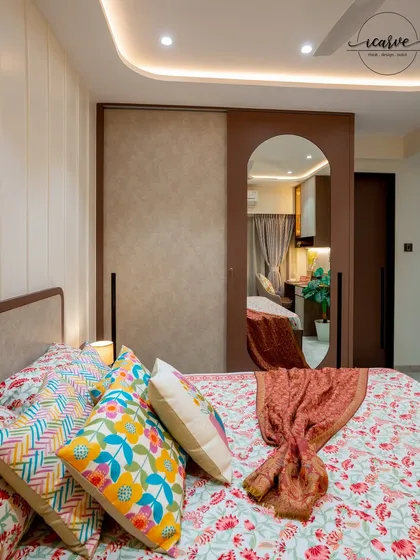 The sliding wardrobe in this room features an arched mirror, adding both functionality and a design element.