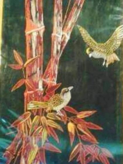 A beautiful and intricate painting made from slivers of bamboo, created by an artisan in Imphal. This unique piece of art, depicting birds on bamboo stalks, showcases the incredible versatility of bamboo as an artistic medium.