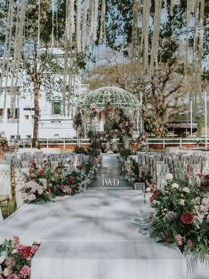 A grand aisle setup for a vintage-themed wedding by the sea. The decor combines classic English garden elements with the beauty of the Mumbai coastline.