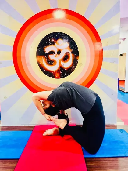 A student holds a deep Ustrasana (Camel Pose), opening her heart and stretching the entire front of her body. This is a powerful and energizing backbend.