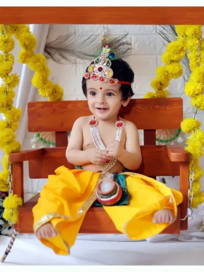 A wide shot of our Janmashtami swing setup, showing the full arrangement with a white curtain and marigold garlands for a festive feel.