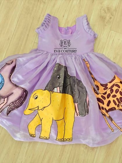 A playful organza frock with colorful, hand-painted animal motifs, perfect for a themed birthday party.