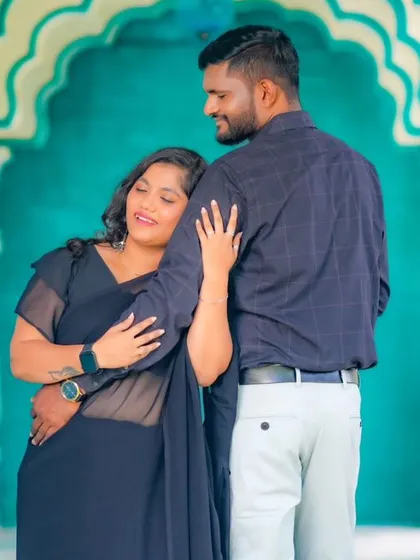 An intimate embrace in a beautiful hallway with white pillars. The bride's sheer black saree adds a touch of modern elegance to this pre-wedding shoot.