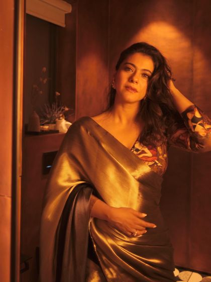 The soft, relaxed pose and flowing hair complement the liquid gold feel of this Shivan and Narresh saree.