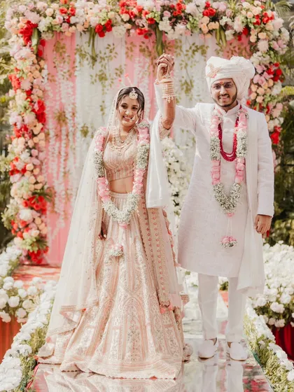 The victory pose. This is a classic wedding portrait that every couple wants, celebrating their union with hands raised high.