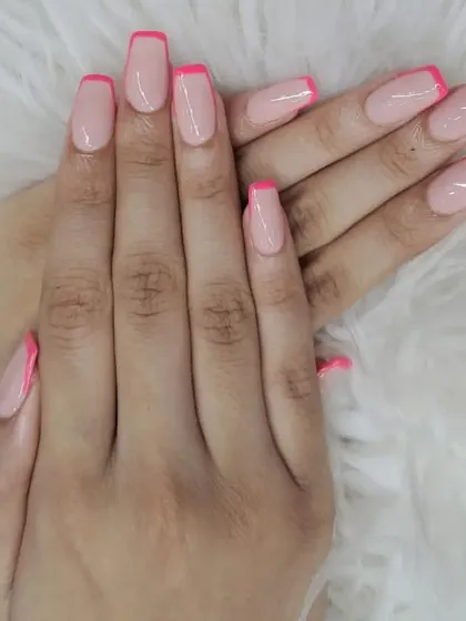 A classic French manicure with a pop of color. This design features clean, squared-off nails with a sheer pink base and vibrant, hot pink tips for a fun and modern twist.