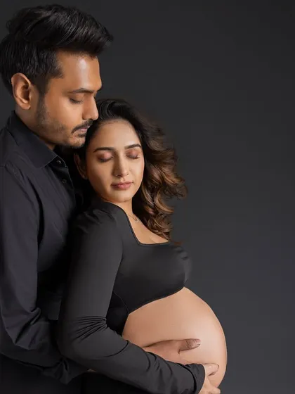A quiet, peaceful moment of connection, with both parents-to-be closing their eyes and cherishing the feeling of their growing baby.