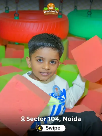 A young boy playing with soft foam blocks in the foam pit. This area is great for building, tumbling, and safe, active play.
