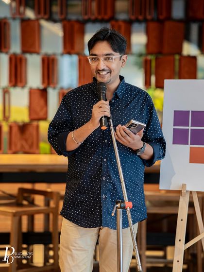 A smiling performer engages the audience at our "Second Chances" open mic. The theme encouraged stories of do-overs, fresh starts, and the courage to begin again.