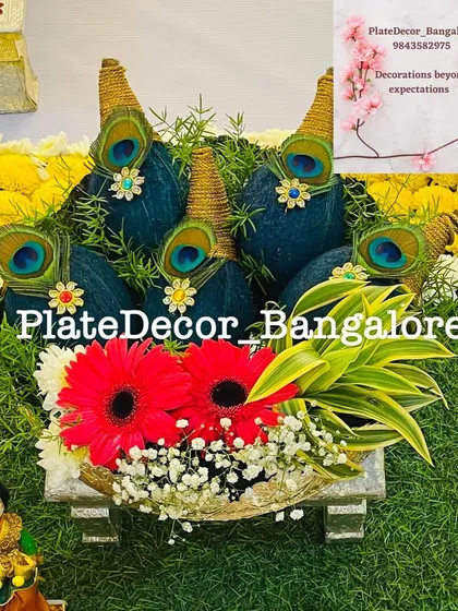 This is a traditional coconut decoration, where I use rich blue velvet, golden thread, and peacock feathers. This type of auspicious platter is perfect for poojas, weddings, and housewarming ceremonies.